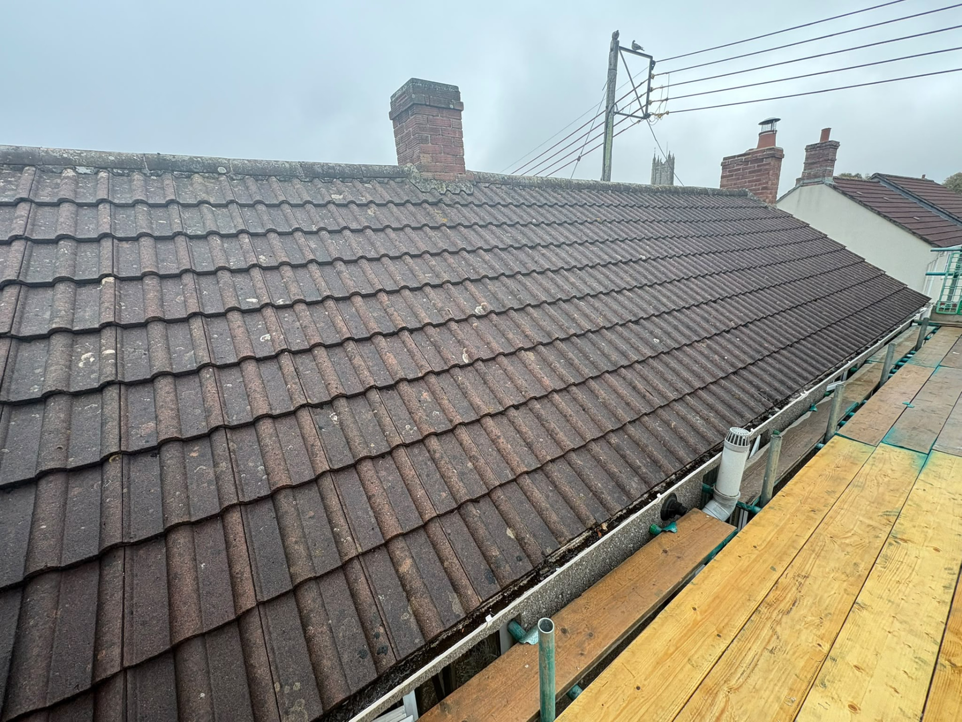 Weathered brown tile roof before re-roofing, scaffold in place, Glastonbury