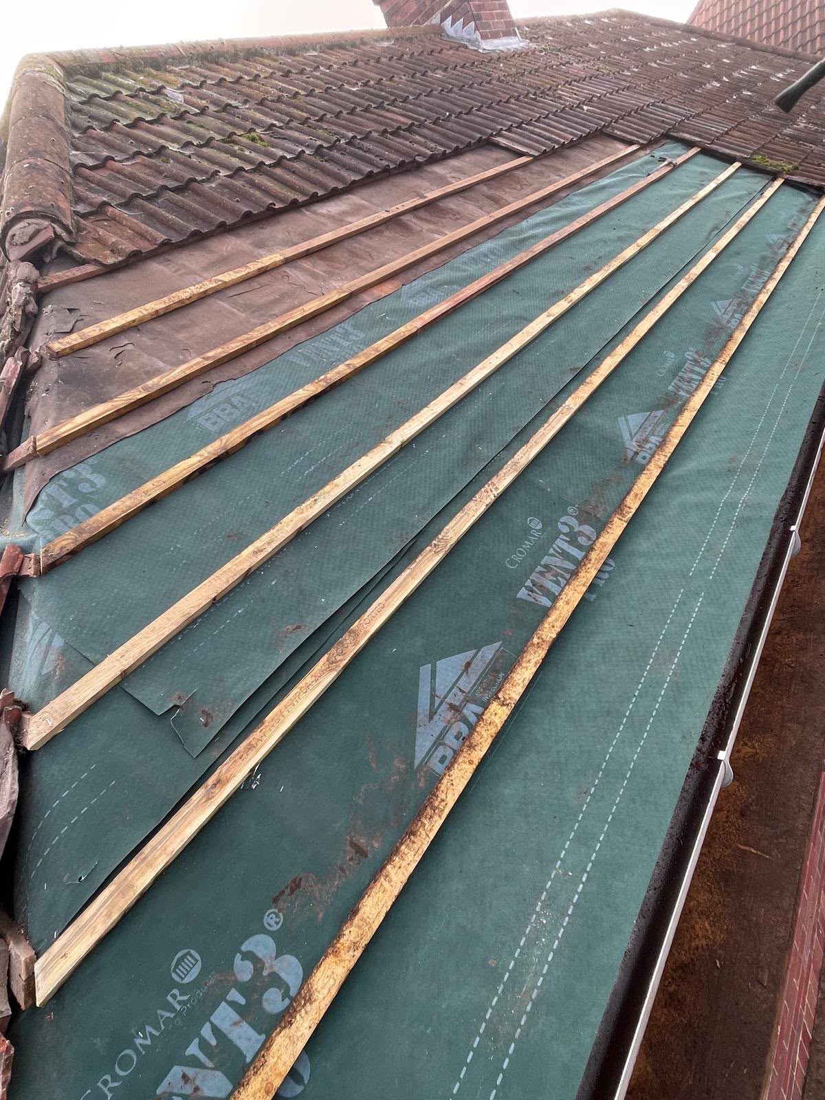 New green breathable membrane and battens fitted beside existing tiles, re-roofing Somerset