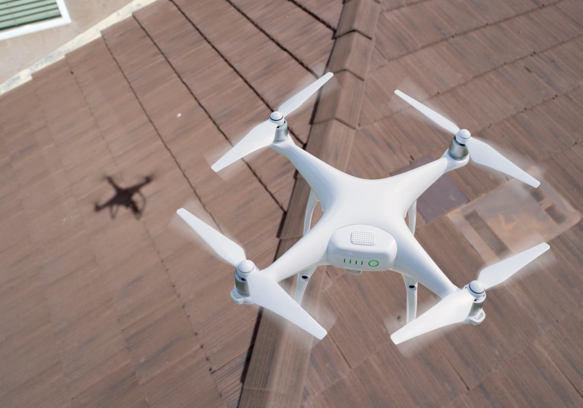Drone flying over a tiled roof during a roof inspection