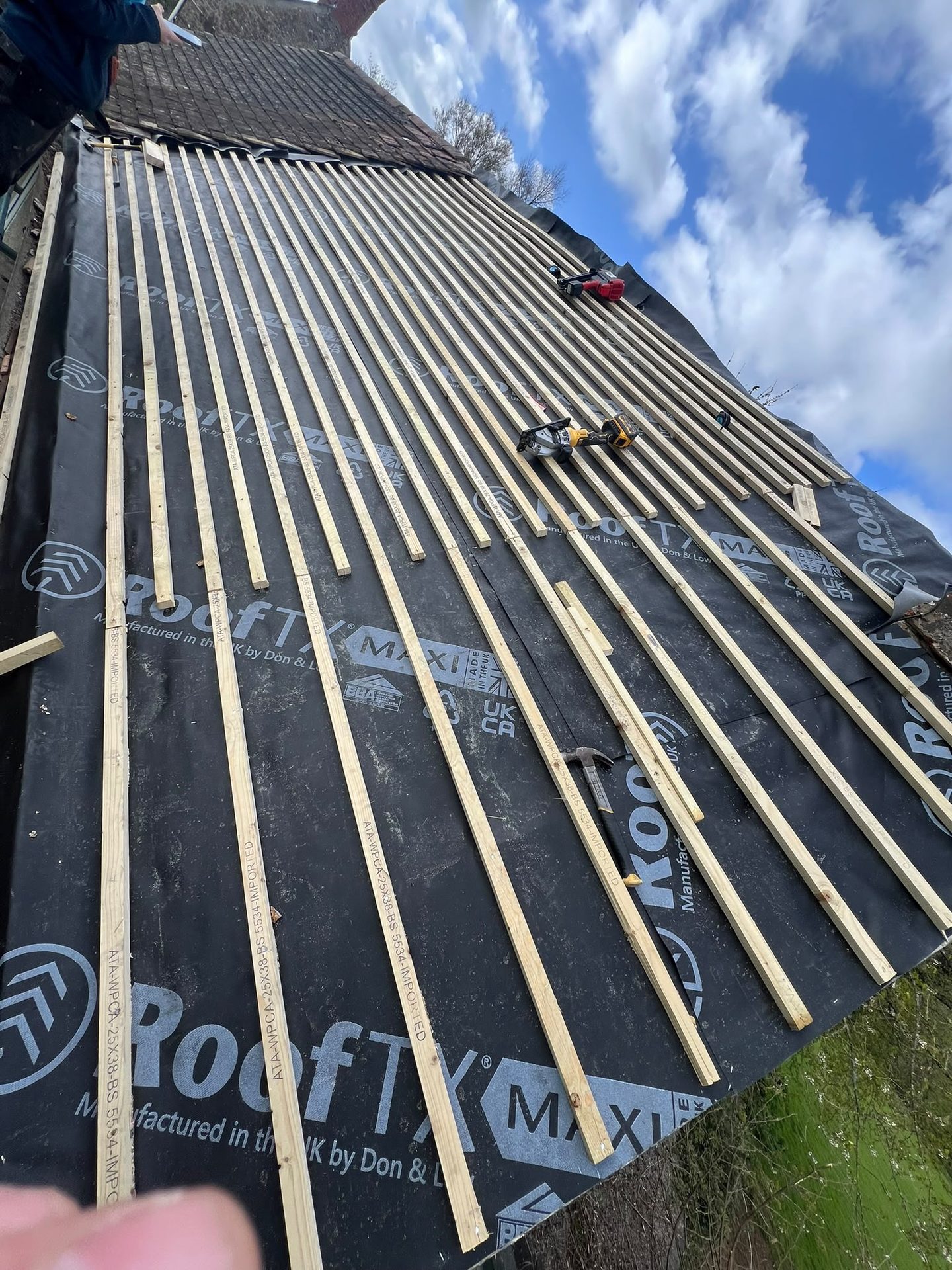 Fresh battens fixed over breathable roof membrane ready for tiling, re-roofing in Glastonbury